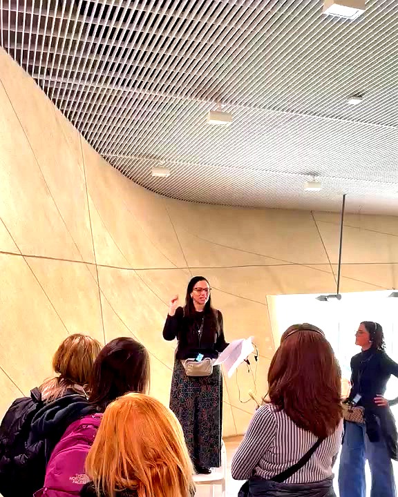 Heather Rossi giving an opening orientation at POLIN Museum in Warsaw to a group of women.